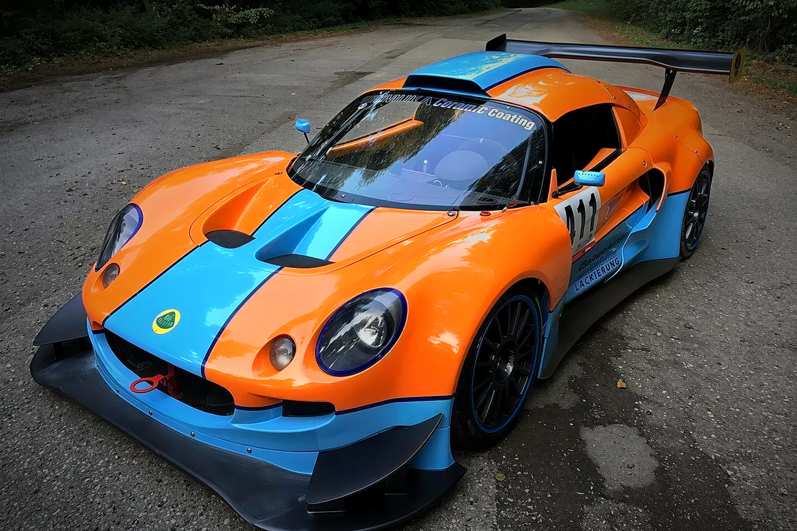 Lotus zákazníka v barvách Gulf se startovním číslem 111 na lesní silnici